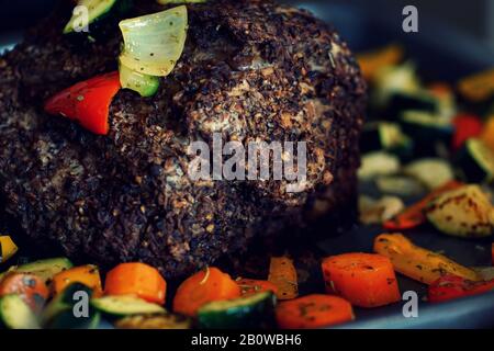 primo piano di maiale arrosto con crosta di sesamo e verdure grigliate Foto Stock