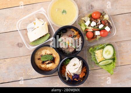 Cibo di strada, consegna e cibo pulito concetto. Piano pasti giornalieri. Varietà di nutrizione adeguata e dieta equilibrata in contenitori di cibo su legno rustico Foto Stock