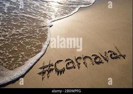 Messaggio moderno per il Carnevale (portoghese per il carnevale) con un hashtag sociale-amichevole scritto su spiaggia di sabbia liscia Foto Stock
