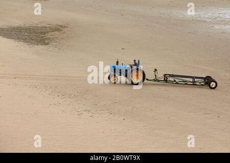 Trattore per il recupero di imbarcazioni che traina rimorchi vuoti lungo la spiaggia sulla costa nord del galles a abersoch nel regno unito Foto Stock