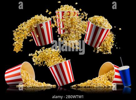 Insieme di strisce di carta benne con popcorn e tazze di soft drink isolati su sfondo nero, movie notte concepto o guardare la TV. Foto Stock