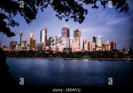 Skyline della città di Sydney attraverso il porto al tramonto, Australia Foto Stock