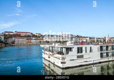 Budapest, Ungheria - 6 novembre 2019: Enorme nave da crociera turistica sul Danubio nella capitale ungherese. Centro storico con il complesso del Castello di Buda e la Chiesa di Mattia sullo sfondo. Foto Stock