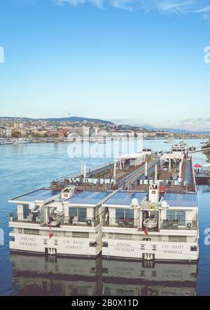 Budapest, Ungheria - 6 novembre 2019: Enorme nave da crociera turistica sul Danubio nella capitale ungherese. Centro storico in fondo. Foto verticale con filtro. Foto Stock