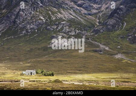 Casa solitaria di fronte ad una montagna a Glencoe nelle Highlands scozzesi, Scozia, Gran Bretagna, Foto Stock