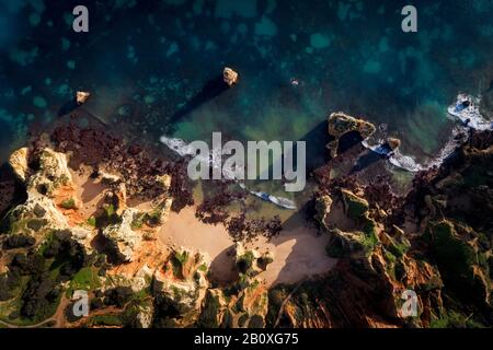 Foto aerea del drone della bellissima spiaggia di Camilo (Praia do Camilo) con il mare e le scogliere, a Lagos, Algarve, Portogallo Foto Stock