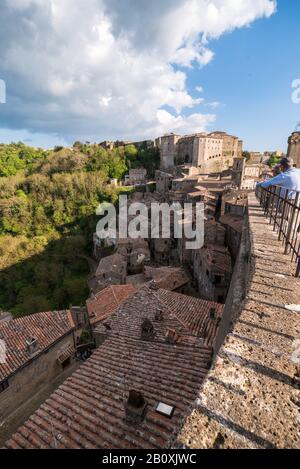 Vista panoramica del paese in Italia con case in mattoni rossi a Sovana Sorano con cielo bellissimo con nuvole nella provincia Lazio Viterbo in Italia Foto Stock