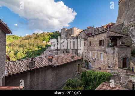 Vista panoramica del paese in Italia con case in mattoni rossi a Sovana Sorano con cielo bellissimo con nuvole nella provincia Lazio Viterbo in Italia Foto Stock
