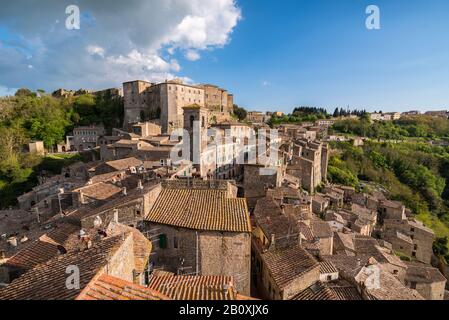 Vista panoramica del paese in Italia con case in mattoni rossi a Sovana Sorano con cielo bellissimo con nuvole nella provincia Lazio Viterbo in Italia Foto Stock