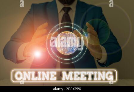 Scrittura concettuale della mano che mostra il meeting online. Concetto che significa una riunione che si svolge su Un mezzo elettronico Elementi di questa immagine arredata Foto Stock