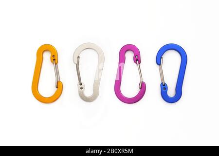 Quattro moschettoni con porta a filo piccolo non utilizzati per l'arrampicata, ma per appendere accessori o chiavi. Moschettoni colorati isolati su sfondo bianco - TOP dow Foto Stock