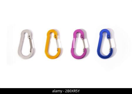 Quattro moschettoni colorati (argento, arancione, viola, blu) di fila, isolati su sfondo bianco - vista dall'alto verso il basso. Non fatto per l'arrampicata, questi mini fili Foto Stock