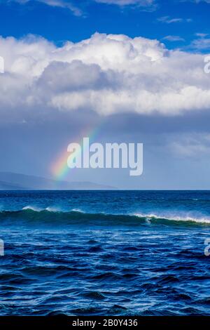 Apollo Bay con la pioggia che si avvicina causando la formazione di un piccolo arcobaleno sull'acqua. Victoria, Australia Foto Stock