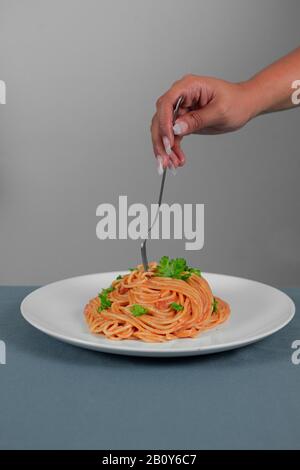 Spaghetti in salsa rossa con prosciutto di maiale Foto Stock
