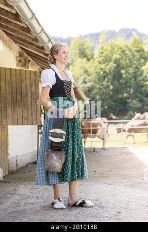 Contadino con dirndl che indossa una campana Foto Stock
