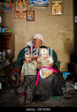 I tibetani vivono in abitazioni modeste, tutte insieme, con le loro mura coperte da icone e manifesti religiosi. Altopiano tibetano remoto Foto Stock