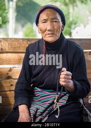 Vecchia donna tibetana pregando, altopiano Tibetano Foto Stock
