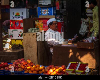 Mumbai, India - 18 dicembre 2019 : fornitore indiano di frutta con la PAC tradizionale al mercato di Crowford. I fornitori di frutta stanno vendendo la varietà di frutta nella strada s. Foto Stock
