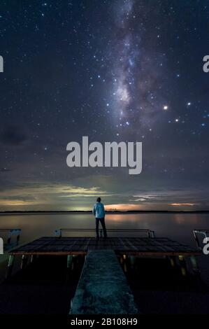 Milky Way e fulmini distanti dietro il ponte pedonale del campo Catatumbo (catatumbo temporale, il luogo con la più alta densità di fulmini sulla terra) Ologa, Zulia, Venezuela, Sud America Foto Stock