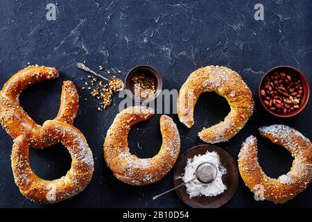 Panini dolci austriaci cosparsi di arachidi e zucchero a velo su fondo di cemento scuro, vista dall'alto, copia Foto Stock