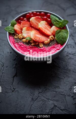 Bacche frullato estivo o ciotola di yogurt con fragole, ribes rosso e semi di chia su nero Foto Stock