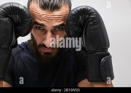 Immagine di giovane sportivo muscolare che indossa tuta boxe in guanti isolati su sfondo bianco Foto Stock