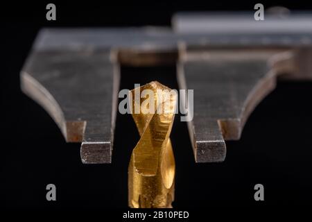 Misurazione della pinza con diametro di foratura. Misurazione degli accessori nell'industria carpenteria. Sfondo scuro. Foto Stock