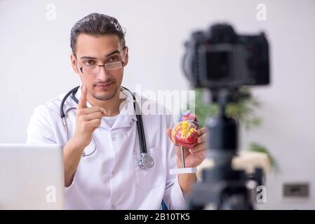 Il giovane maschio medico cardiologo di registrazione di video per il suo blog Foto Stock