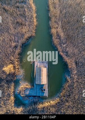 Una piccola capanna in un campo di canne nel mezzo della Schilfgürtel di Neusiedler Vedere vicino Breitenbrunn a Burgenland Austria in una fredda mattina invernale con Foto Stock