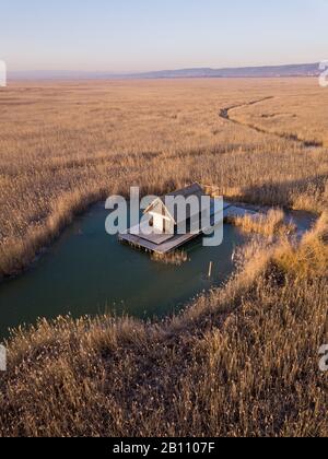 Una piccola capanna in un campo di canne nel mezzo della Schilfgürtel di Neusiedler Vedere vicino Breitenbrunn a Burgenland Austria in una fredda mattina invernale con Foto Stock