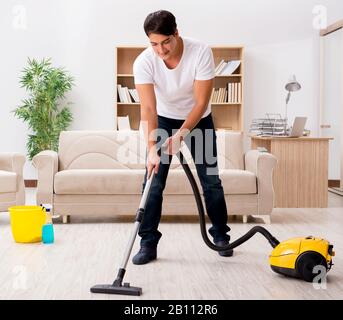 L'uomo che pulisce a casa con l'aspirapolvere Foto stock - Alamy