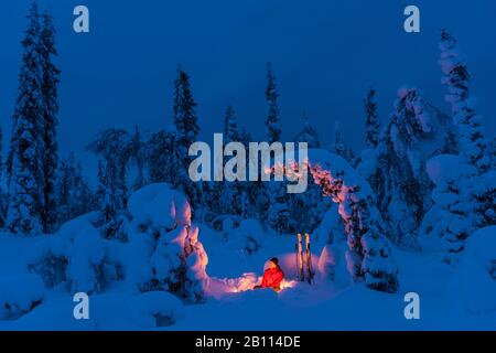 Uomo in un falò, Svezia, Lapponia, Norrbotten, Muddus NP Foto Stock