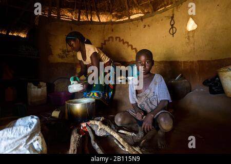 Scena quotidiana in una tradizionale capanna di paglia, Mozambico, Africa Foto Stock