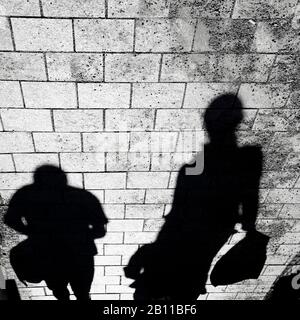 Silhouette sfumata di persone che camminano sul marciapiede della strada in bianco e nero ad alto contrasto, capovolto Foto Stock