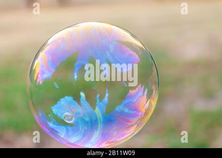 Una bolla di sapone solo colorato con riflessi Foto Stock