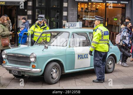 Londra, 26 Gennaio 2020. Policemans in piedi dalla sua auto di polizia.Police firma su una Austin Patrol car.AUSTIN1300 polizia Panda auto Foto Stock