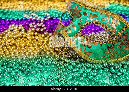 Composizione festiva Mardi Gras da maschera carnevale su uno sfondo di perle multicolore con spazio per il testo Foto Stock