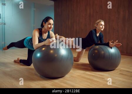 Due donne slim, pilates formazione su palle in palestra Foto Stock