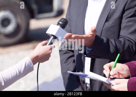 Reporter che fanno intervista di mezzi con la persona di affari o il politico Foto Stock