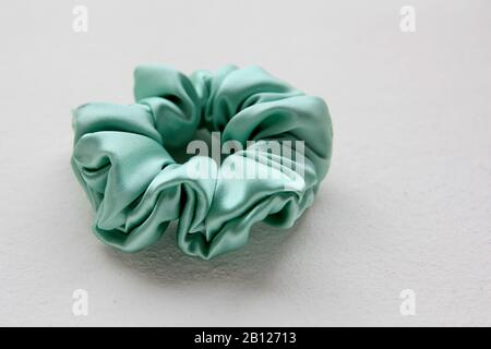 Seta turchese Scrunchy isolato su sfondo bianco. Parrucchiere A Disposizione Piatta Con Banda Elastica Colorata, Banda Hairband Bobble Scrunchie Foto Stock