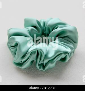 Seta turchese Scrunchy isolato su sfondo bianco. Parrucchiere A Disposizione Piatta Con Banda Elastica Colorata, Banda Hairband Bobble Scrunchie Foto Stock