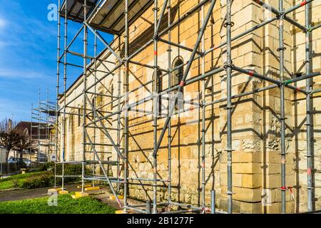 Ponteggio modulare eretto intorno alla vecchia chiesa per la pulizia e la ristrutturazione della pietra, Bossay-sur-Claise, Francia. Foto Stock