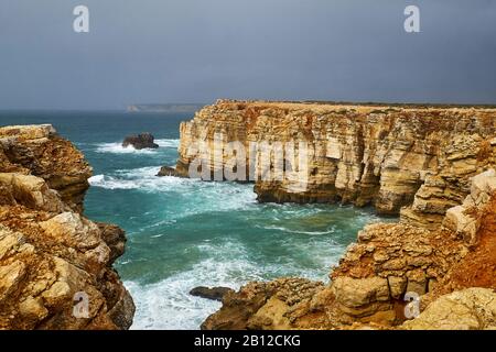 Costa rocciosa a Cabo de Sao Vicente con mare tempestoso vicino Sarges, Algarve, Faro, Portogallo Foto Stock