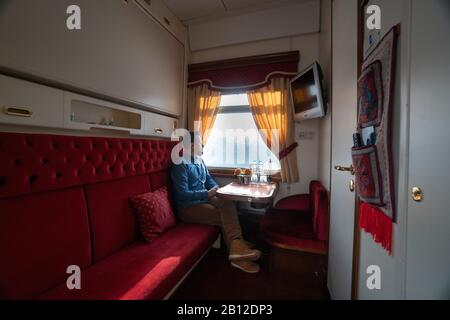 Trans-Siberian ferrovia in inverno, uomo seduto in treno guardando fuori della finestra, Russia Foto Stock