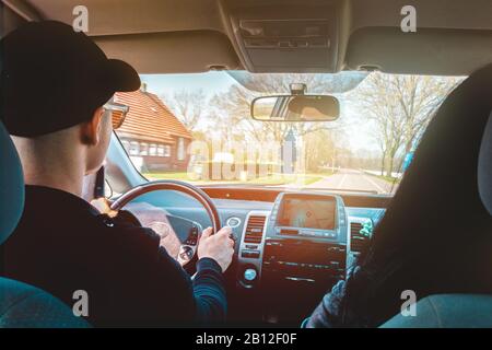 concentrato sulla guida. uomo che guida una macchina con sua moglie da lui presto la mattina Foto Stock