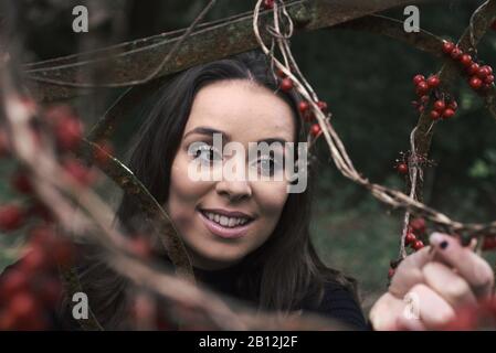 Donna sorridente che raccoglie bacche Foto Stock