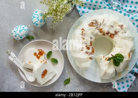 Dessert di Pannacotta. Cottage souffle di formaggio panna cotta con albicocche e decorazioni di cocco su una pietra o ardesia su un piano di lavoro leggero. Vista dall'alto piano Lay ba Foto Stock