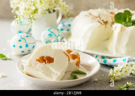 Dessert di Pannacotta. Cottage souffle di formaggio panna cotta con albicocche su una pietra o ardesia su un piano di lavoro leggero. Foto Stock