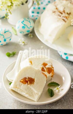 Dessert di Pannacotta. Cottage souffle di formaggio panna cotta con albicocche su una pietra o ardesia su un piano di lavoro leggero. Foto Stock