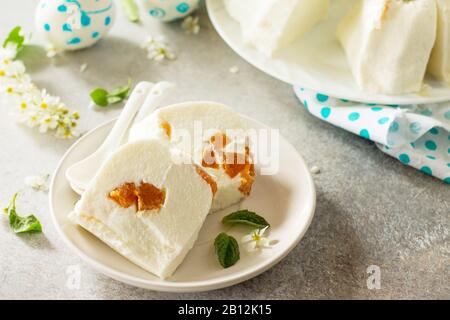 Dessert di Pannacotta. Cottage souffle di formaggio panna cotta con albicocche su una pietra o ardesia su un piano di lavoro leggero. Foto Stock